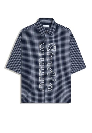 Marineblå kortærmet skjorte med knapper og hvidternet mønster samt lodret hvidt omrids af teksten "Studium" ned langs fronten.