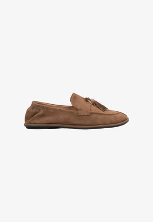 Bruine suède platte loafer met kwastjes en een kraaldetail op het bovenwerk, met een zwarte zool en elastische hiel.