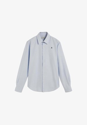 Cămașă bleu deschis cu mânecă lungă, cu guler și un mic logo cu craniu și oase încrucișate, de culoare neagră, pe partea stângă a pieptului.