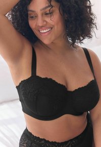 Reggiseno in pizzo nero con motivi floreali, supporto con ferretto e spalline regolabili. Tessuto morbido con bordi delicati.