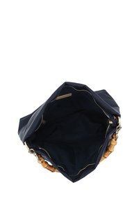 Navy fabric bag with a soft texture and gold zipper. Interior is dark, featuring a tan strap with wooden accents. Open top design.