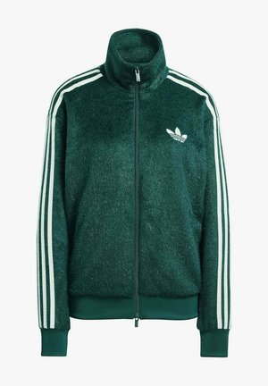 Giacca verde in pile con zip e collo alto, strisce bianche lungo le maniche e un piccolo logo bianco sul petto. Tessuto morbido.