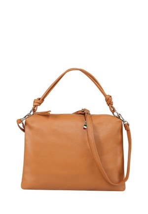 Sac à main en cuir fauve avec deux poignées nouées, des ferrures argentées et un petit porte-bonheur en forme de drapeau tricolore accroché au curseur de la fermeture éclair.