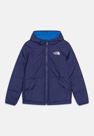 Marineblå polstret jakke med hætte, frontlynlås, to lommer og The North Face-logo på brystet; hætte foret med lys blå stof.