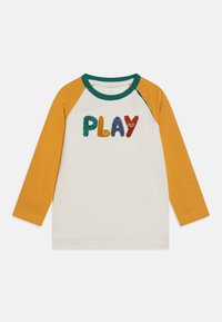 T-shirt a maniche lunghe con corpo bianco, maniche giallo senape, colletto verde e lettere ricamate colorate e morbide che formano la parola "PLAY."