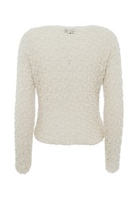 Maglione a maniche lunghe in bianco sporco, con un motivo testurizzato simile a pizzo e scollatura a barca; dettagli sottili includono un piccolo apertura sul retro.