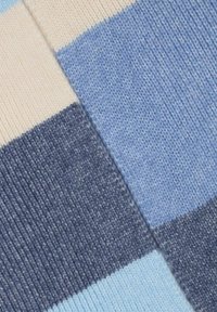 Knitted textile featuring alternating stripes in light blue, dark blue, and cream, with a smooth texture and consistent pattern throughout.