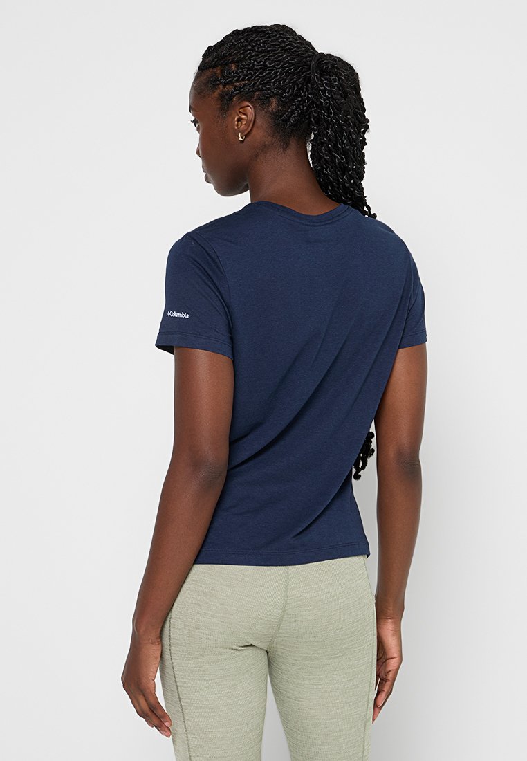 T-shirt en coton bleu marine avec un col rond, des manches courtes et un petit logo sur l'épaule gauche. Texture lisse et design ajusté.