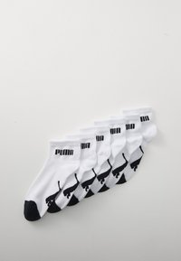 Vita ankelsockor set, med svarta accenter på tån och hälen. Varje strumpa har en svart Puma-logotyp och siluett. Mjuk blandning av bomull.
