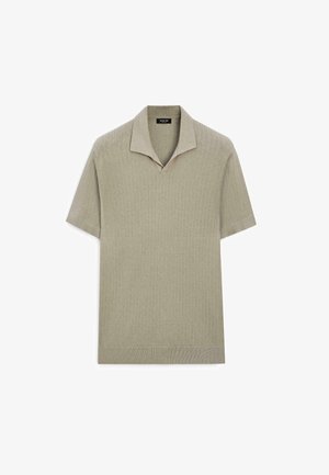 Polo en maille beige clair à manches courtes avec motif texturé et col ouvert.