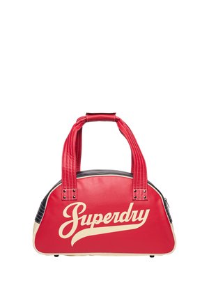 Bolso Superdry rojo y crema con dos asas rojas y un ribete negro y crema sobre un fondo blanco.