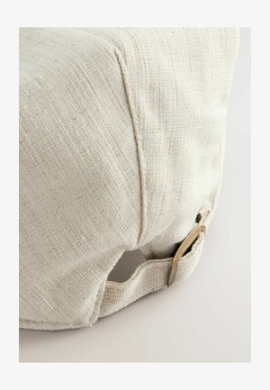 Cesta de almacenamiento de lino en color blanco roto con una superficie texturizada, que cuenta con una abertura lateral y un acento metálico en tono dorado para facilitar el manejo.