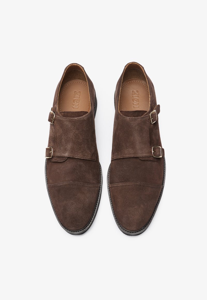 Chaussures en daim marron avec un design à double attache et des détails cousus, dotées d'une doublure intérieure lisse et d'une semelle en caoutchouc.