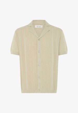 Maglia beige a maniche corte con trama a costine verticali, colletto aperto e cinque bottoni frontali.