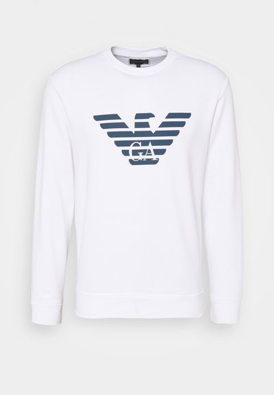 Sweatshirt blanc avec un graphique de logo rayé bleu sur le devant, col rond et manches longues. Matière en coton lisse.