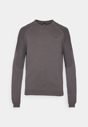Suéter gris con textura acanalada en los hombros y las mangas, escote redondo y sutil detalle del logo en el pecho. Mangas largas, diseño ajustado.