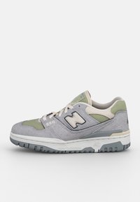 Chaussure de sport grise et verte en daim et mesh, dotée d'un col rembourré, d'un détail de logo et d'une semelle en caoutchouc contrastante.