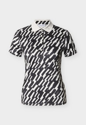 Πολό μπλούζα με ασπρόμαυρο μοτίβο, γιακά, κοντά μανίκια και κούμπωμα με κουμπιά. Διαθέτει λογότυπο στο αριστερό μανίκι.