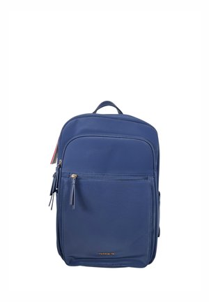 Zaino blu navy con tasca frontale con zip, cursori dorati, maniglia superiore e logo discreto vicino al centro inferiore.
