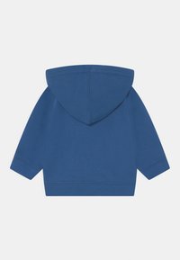 Jednobarevná modrá mikina pro batolata s dlouhými rukávy a žebrovanými manžetami a spodním lemem, zobrazená ze zadní strany na bílém pozadí.