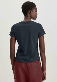 T-shirt in cotone blu navy con maniche corte, scollatura rotonda e vestibilità comoda; texture liscia, design semplice e senza motivi visibili.