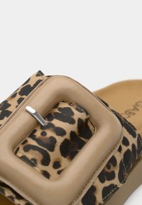 Leopardmønstret sandal med beige rem, der har en stor firkantet spænde og blødt tekstureret materiale for komfort.