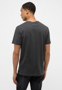 Camiseta de algodón gris carbón con un diseño sencillo, cuello redondo, mangas cortas y una textura suave, con un dobladillo recto.