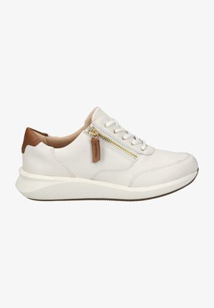 White leather sneaker with a rounded toe, beige accents, a side zipper, and flat beige outsole. Features laces and stitching details.