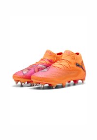 Scarpe da calcio di un vivace arancione e rosa con un motivo testurizzato, un collo alto e dettagli argentati. Dotate di molteplici tacchetti per una migliore aderenza.
