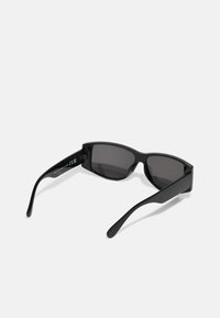 Gafas de sol rectangulares negras con lentes oscuros y un marco de plástico brillante. Presentan brazos curvados y cónicos y una marca mínima en el interior.
