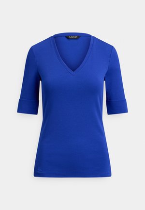 Modré tričko s výstřihem do V, tři čtvrtě délky rukávů s ohrnutými lemy, hladká textura, vypasovaný střih a nenápadné logo poblíž lemu.