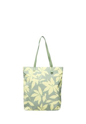 Tragetasche mit hellgrünen Trägern und großem blassgelbem Muster tropischer Blätter auf einem gedämpften grünen Hintergrund.