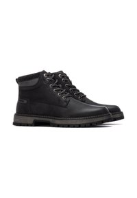 Botas de tobillo de cuero negro con un acabado texturizado, collar acolchado y ojales de metal. Suela de goma con un diseño resistente para mayor tracción.
