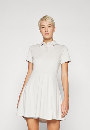 Light gray polo dress made from smooth fabric, featuring short sleeves, a buttoned placket, and a flared A-line skirt.