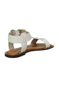 Sandalo piatto bianco in materiale liscio, con due cinture superiori e chiusura con fibbia. Suola marrone con una leggera curvatura. Design minimalista.