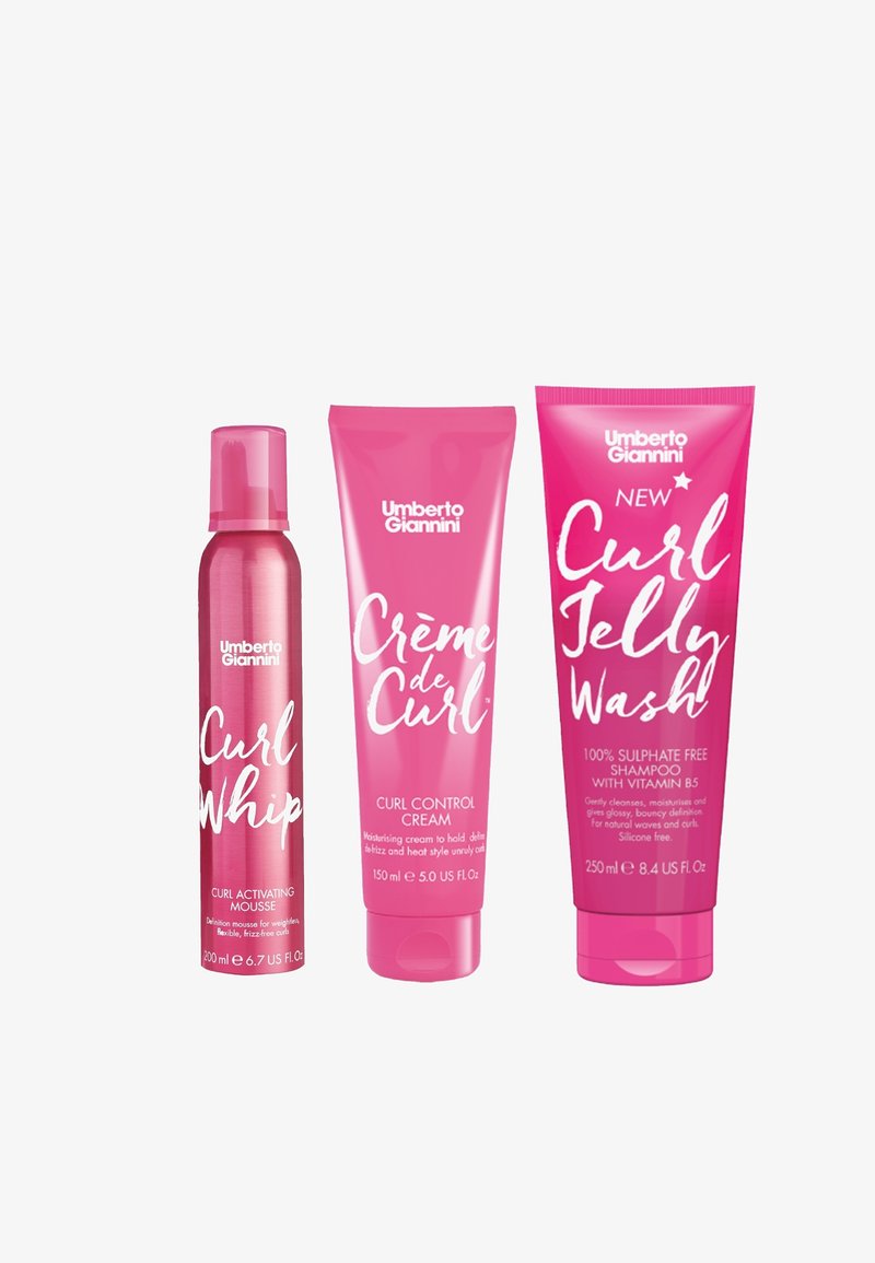 Drie haarverzorgingsproducten: een roze mousse spuitbus, een roze krulcontrolcrème tube en een roze shampoo fles, allemaal van het merk Umberto Giannini.