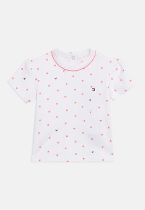 Άσπρο μπλουζάκι μωρού με κοντά μανίκια, ροζ σχέδιο καρδιάς, διακοσμητικό βολάν στη λαιμόκοψη και κούμπωμα με κουμπιά στον ποδόγυρο.