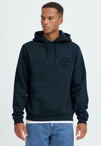 Felpa con cappuccio blu navy realizzata in tessuto morbido, dotata di tasca frontale, cappuccio con coulisse regolabile e logo a rilievo a forma di mappamondo sul petto.