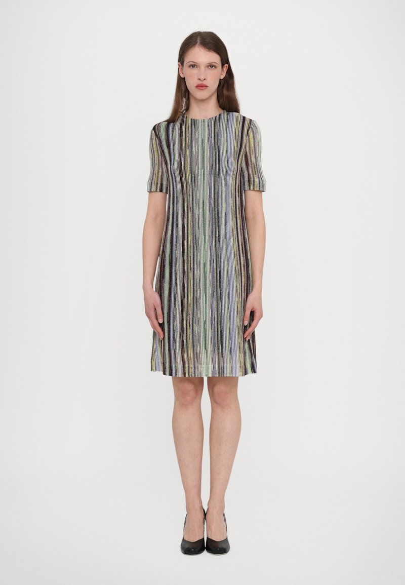 Rochie cu mânecă scurtă, cu dungi verticale multicolore, cu o siluetă până la genunchi și țesătură texturată. Pantofii negri completează aspectul.