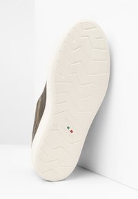 Braunes Lederschuh mit einer weißen Gummisohle, die ein strukturiertes Zickzackmuster aufweist. Die Sohle ist mit "NeroGiardini" und "37 Made in Italy" gekennzeichnet.