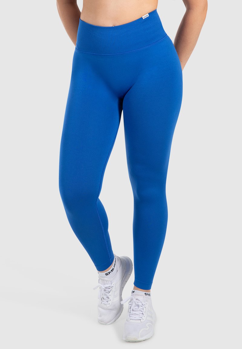 Höga blå idrottsleggings i stretchigt material, med en mjuk textur och en sömlös design för komfort.
