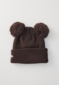 Ruskea neulottu pipo, jossa on kaksi suurta, pörröistä pom-pomia päällä ja ribbauslahje. Sivulla on pieni valkoinen logo.