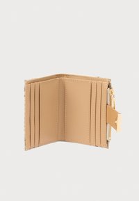 Portefeuille plié en cuir beige avec plusieurs emplacements pour cartes, une poche zippée et des accessoires en métal doré. Texture lisse avec des détails cousus.