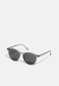 Runde Sonnenbrille mit einem klaren grauen Rahmen, dunklen Gläsern und schmalen Bügeln. Sie hat ein minimales Design ohne sichtbare Muster oder Akzente.