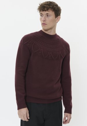 Bordeauxfarbener Strickpullover mit einer strukturierten, gemusterten Passe, Rundhalsausschnitt und gerippten Bündchen, entworfen für eine figurbetonte Silhouette.