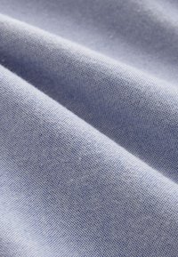 Hellblauer Stoff mit einer glatten Textur, feiner Webart und subtiler Schimmer. Zeigt sanfte Falten und eine gleichmäßige Farbe.