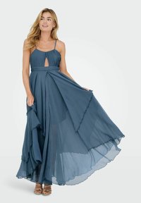 Sukienka maxi w ciemnym odcieniu teal z plisowanym życiem, wycięciem w kształcie klucza, zwiewnym, falbaniastym dołem i cienkimi ramiączkami. Miękka, lekka tkanina.