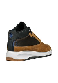 Zapatilla alta de cuero marrón y textil con acentos negros, mediasuela blanca, superficie texturizada y detalles azules cerca del talón.