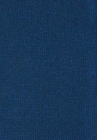 Tejido de punto azul oscuro con una textura suave, que presenta finas costillas. El material parece uniforme sin patrones o acentos notables.