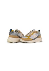 Zapatillas que presentan una mezcla de materiales de ante y malla en tonos gris, beige y mostaza, con una suela gruesa de color claro y acentos en azul.